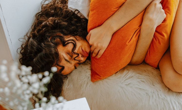 A woman lying on a sofa looking ill while suffering from pregabalin withdrawal symptoms - Step By Step Recovery